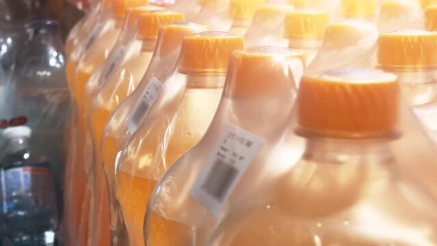 Orange soda in 2-liter bottles, packed in 6 bottles, is in the beverage production warehouse. Closeup 