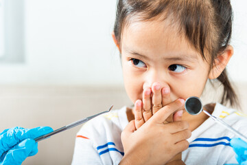 Dental kid examination. Doctor examines oral cavity of child uses mouth mirror to check teeth...