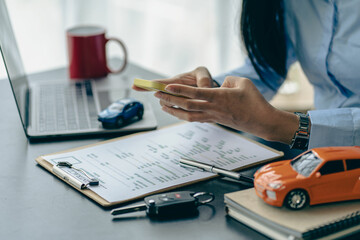 Car rental sales concept, Asian businesswoman working with toy cars on the table. Concepts of cars,...