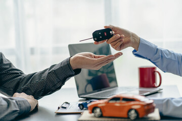 of the representative Hold the car keys to the new owner after signing the leasing contract in the car sales contract document.