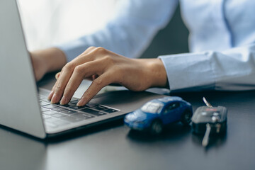 Car rental sales concept, Asian businesswoman working with toy cars on the table. Concepts of cars, property, ownership, insurance and transportation.