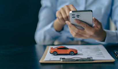 Car rental sales concept, Asian businesswoman working with toy cars on the table. Concepts of cars, property, ownership, insurance and transportation.