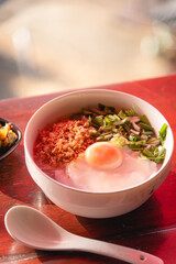 Closed up rice porridge with eggs and minced pork on wooden table