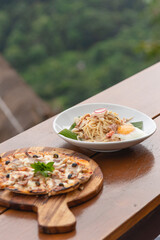 Pizza and Spaghetti carbonara with ham on wooden table