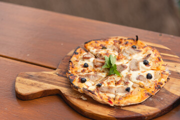 Homemade pizza with bacon and cheese on wooden table background