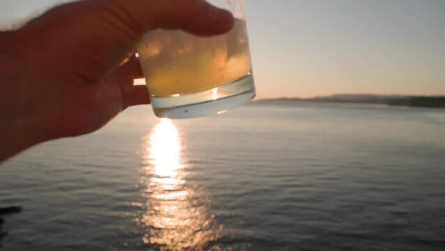 Sunset cocktail by the ocean, margarita, fancy drink, drinking, beach cocktail, vacation. 4K 24FPS.