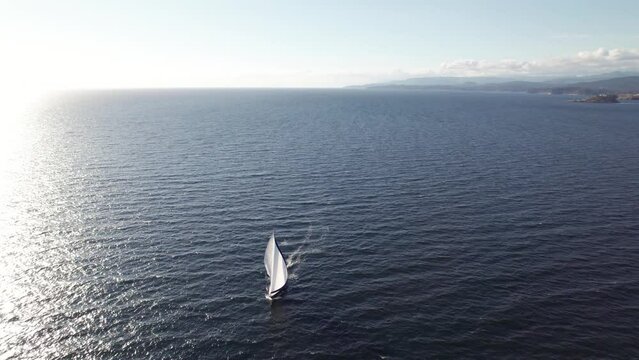 Sailboat near coastline, aerial drone footage, Vancouver Island, Sooke BC, sunny day ocean. 4K 24FPS.