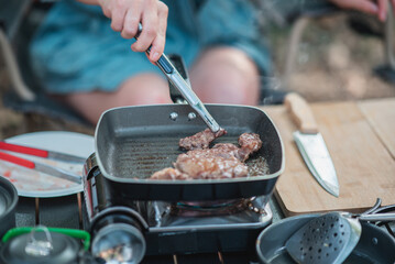Young women enjoy to cooking meal on camping