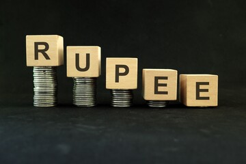 Indian rupee weakening, value depreciation and devaluation concept. Decreasing stack of coins on...