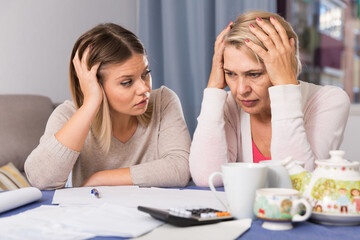 Mother and her adult daughter took on head from bad financial condition and lot of debts. - obrazy, fototapety, plakaty