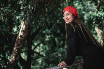 Portrait of Happy Asian young woman in winter costume at the forest with copy space