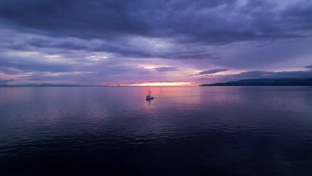 Fishing boat at sunset, aerial drone footage boat in harbour at sunset, Sooke BC, sunset sky. 4K 24FPS.
