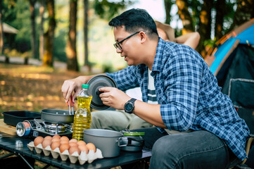 Asian relaxed man sitting and waiting for his friend cooking