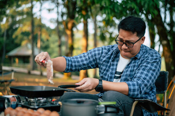 Portrait of Asian traveler man glasses pork steak frying