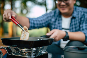Portrait of Asian traveler man glasses pork steak frying