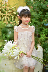 beautiful little girl in elf or fairy dress holding Epiphyllum flower