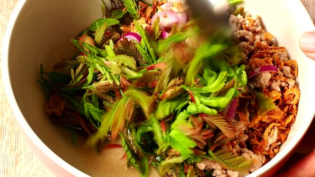 Mixing Young tamarind leaves salad , Thai northern famous food.