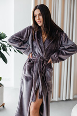 Young healthy serene woman girl relaxing in bathrobe and spa towel after having bath shower at home. Beauty treatment, rest and body care procedures.