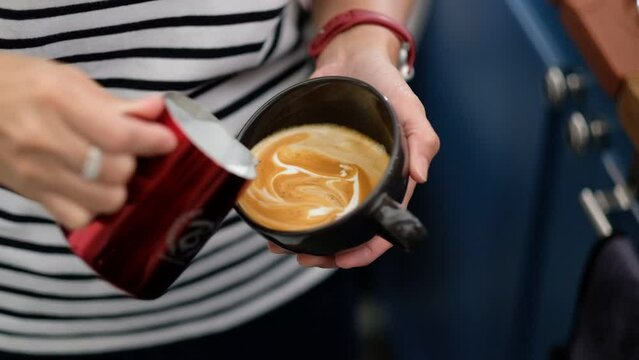 closeup hand doing hot latte art coffee
