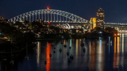 Fototapeta premium Beacons shine from harbourside structures and buildings.