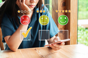 Young woman using smartphone to give a one-star satisfaction rating of the food and drinks at...