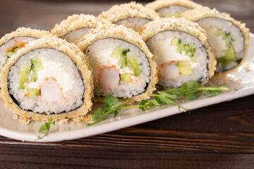 Hot fried sushi roll. Sushi menu. Japanese food. Hot fried sushi roll on plate in restaurant.