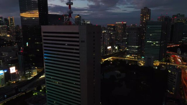 aerial hyper lapse of Tokyo highway traffic, skyscrapers and urban highway in Japan, modern cityscape time lapse transition from day to night