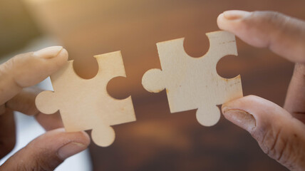 Closeup of hands connecting jigsaws find best business solution or option. Businessman connect pieces of puzzle think of problem solving. Brainstorm, decision concept, success and strategic ideas.