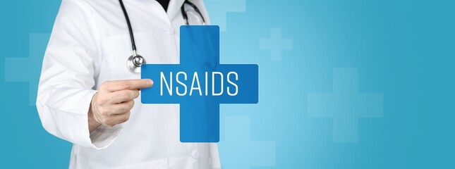 NSAIDs (Non-steroidal anti-inflammatory drugs). Doctor holding blue cross with medical term on it.