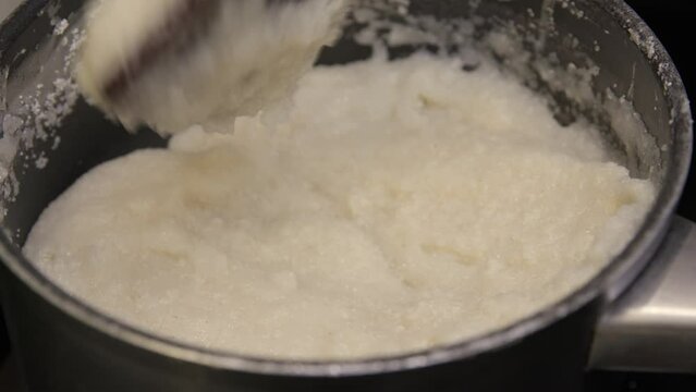 Porridge stirring in a pot, Ugali dish preparation on a stove