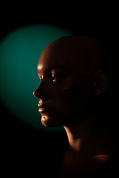 Side view of bald young woman with emotionless face isolated on black background