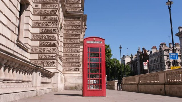 UK red phone box on the London Central Streets. Red British Phone Booth, London background.
