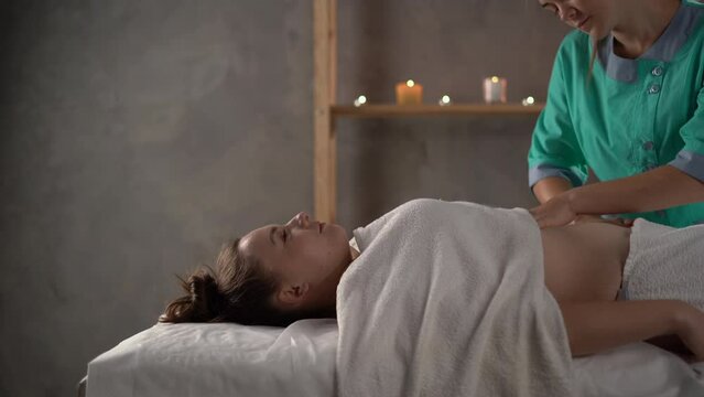 Masseur hands massaging female belly. Therapist applying pressure on the abdomen. lymphatic drainage, manual and aesthetic procedures, hands massaging belly in the spa