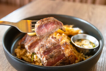 Wagyu beef with holy basil and chili fried rice served fried egg and fish sauce with Thai chilis. Top view on wooden table background.