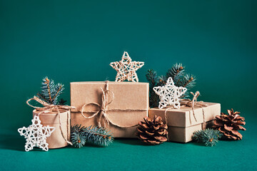 Christmas sustainable gift boxes composition with natural decor on green background. Christmas zero...