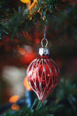 Christmas ornaments hanging in Christmas tree in warm glowing light.