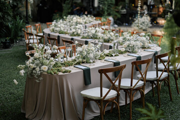 a beautiful wedding decoration arrangement. Table settings. Table Decoration for intimate private party outdoors with fairy light and white flowers. 