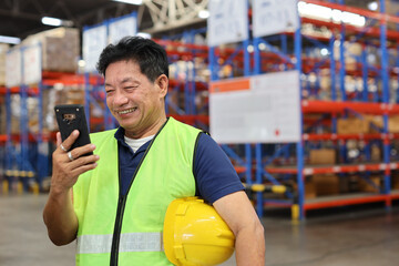 Warehouse workers man with hardhats and reflective jackets using smart mobile phone, walkie talkie...