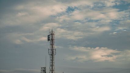Obraz premium Transmitter cellular tower to strengthen and expand the network with cloudy sky background
