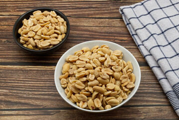 Pealed Peanuts in a bowl isolated on wooden background