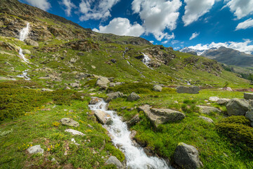 Fototapeta na wymiar Ethereal waterfall and alpine meadows at springtime, Gran Paradiso Alps, Italy