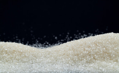 Pile of white sugar crystals on black background
