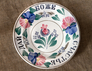 Antique ceramic plate. Translation of the inscription: God bless happiness.