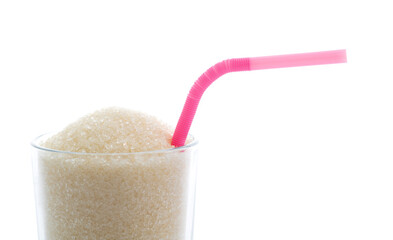 Glass cup full of sugar crystals on white background