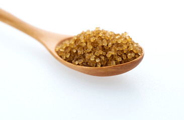 Wooden spoon of brown sugar on white background