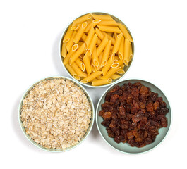 Pasta, oatmeal and raisins on a white background.