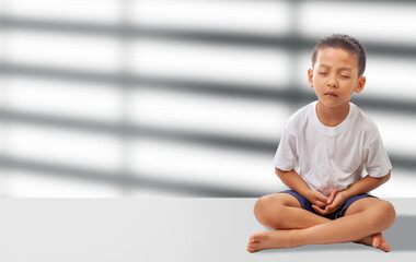 asian boy meditating on white background