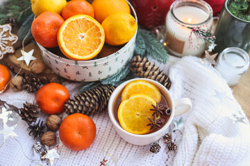 Beautiful Christmas still life. A cup of hot tea with a knitted sixth plaid on the windowsill with New Year's decor