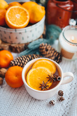 Beautiful Christmas still life. A cup of hot tea with a knitted sixth plaid on the windowsill with New Year's decor
