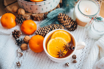 Beautiful Christmas still life. A cup of hot tea with a knitted sixth plaid on the windowsill with New Year's decor